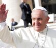 Pope Francis smiles slightly and waves